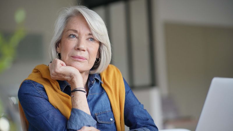 femme cheveux blancs reflechir