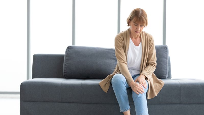 Une femme a des douleurs au genou, dans la fibromyalgie des douleurs peuvent apparaître partout